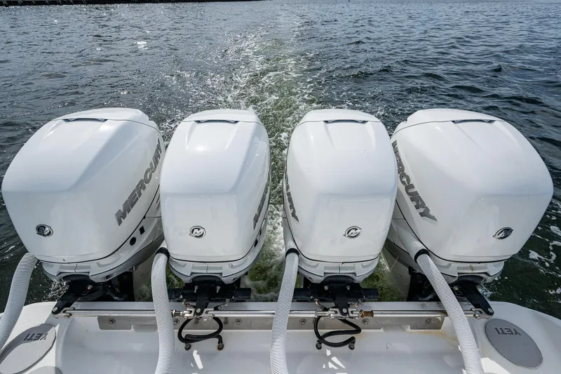 Slide: The Image of Four Mercury outboard engines on a 2015 Bahama 41 boat, cruising on open water. - 12