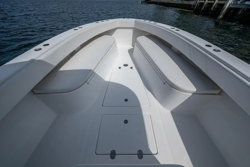 Slide: The Image of 2015 Bahama 41 boat deck with seating, docked by the water. - 2