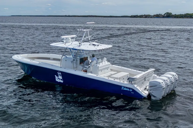 Slide: The Image of 2015 Bahama 41 boat with four Mercury engines cruising on open water. - 25