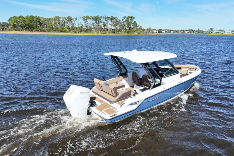 Slide: The Image of 2025 Monterey Elite 27 OB boat cruising on a serene lake under a clear blue sky. - 12