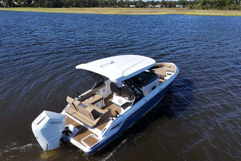 Slide: The Image of 2025 Monterey Elite 27 OB boat cruising on a serene lake. - 17