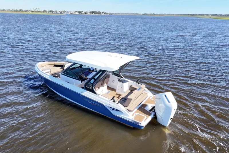 Slide: The Image of 2025 Monterey Elite 27 OB boat cruising on open water, showcasing sleek design and luxury features. - 20