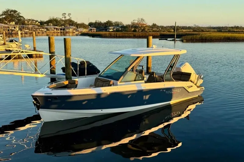 Slide: The Image of 2025 Monterey Elite 27 OB boat docked on calm water at sunset. - 25