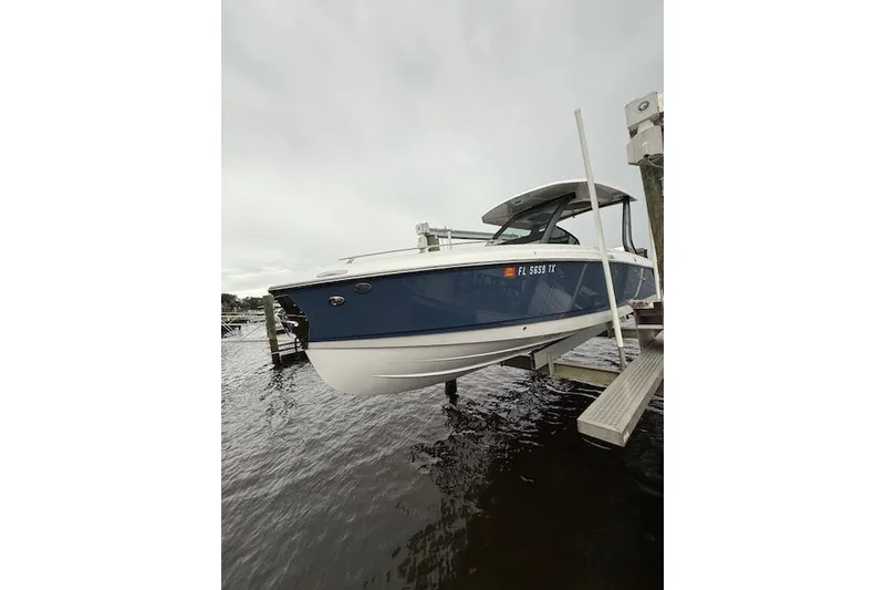 Slide: The Image of 2025 Monterey Elite 27 OB boat docked on water, showcasing sleek blue and white design. - 29