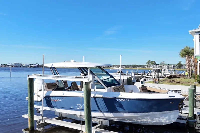 Slide: The Image of 2025 Monterey Elite 27 OB boat docked by a scenic waterfront. - 32