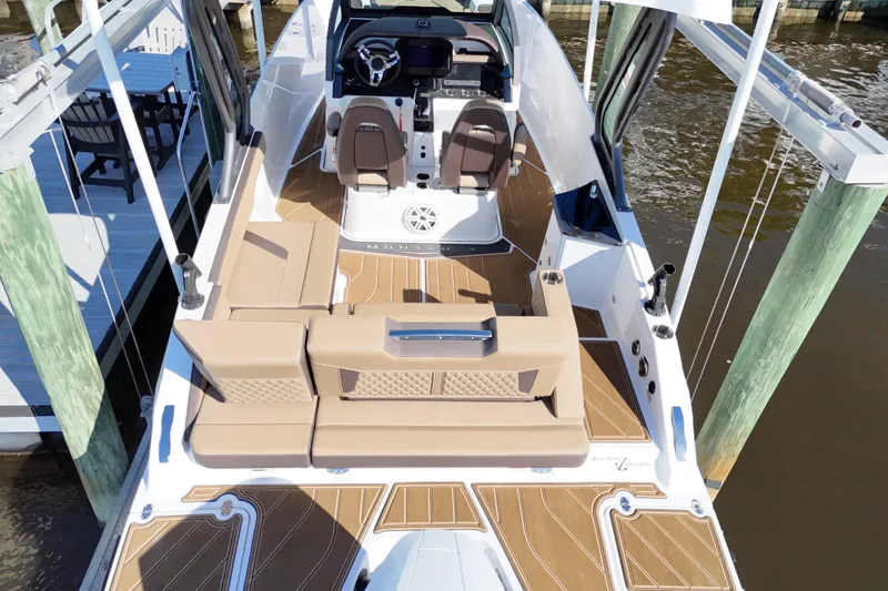 Slide: The Image of 2025 Monterey Elite 27 OB boat with luxurious seating and modern design at a dock. - 36