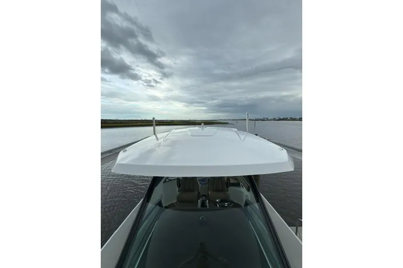 Slide: The Image of 2025 Monterey Elite 27 OB boat on calm water under cloudy sky. - 38
