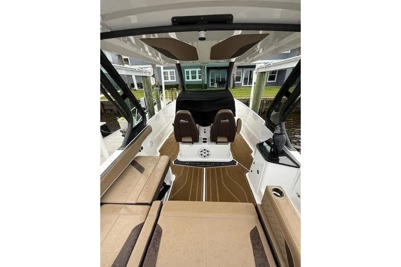 Slide: The Image of 2025 Monterey Elite 27 OB boat interior with brown seating and modern design. - 45