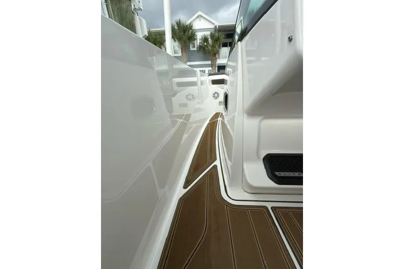 Slide: The Image of 2025 Monterey Elite 27 OB boat deck with sleek design and wood accents. - 46