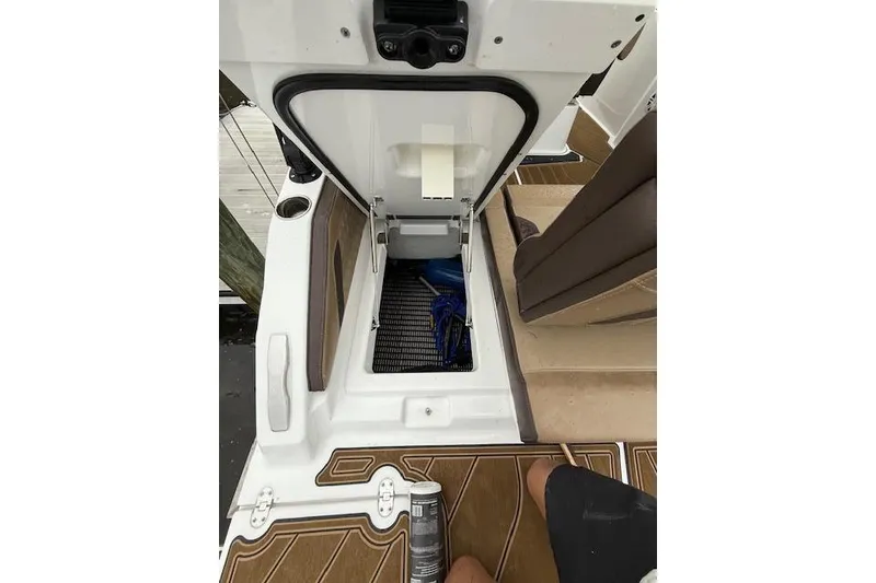 Slide: The Image of Open storage compartment on 2025 Monterey Elite 27 OB boat, featuring brown and white interior. - 51
