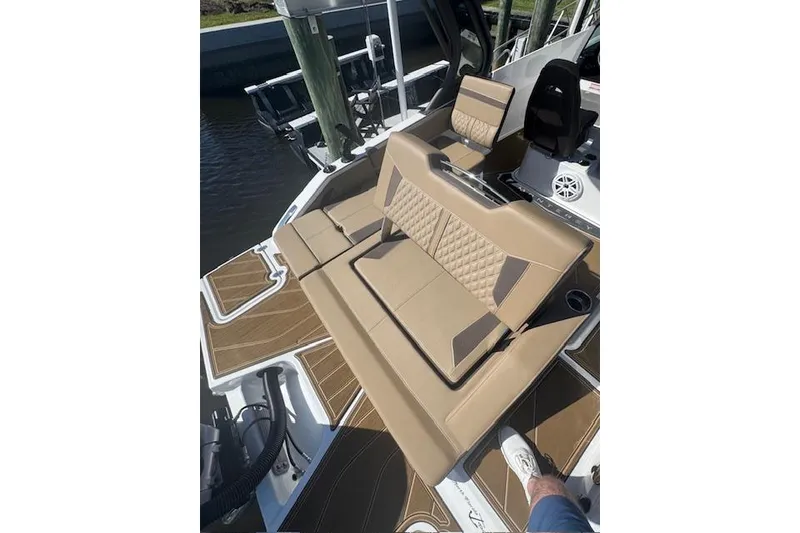 Slide: The Image of Luxurious seating on 2025 Monterey Elite 27 OB boat, featuring tan upholstery and stylish design. - 54