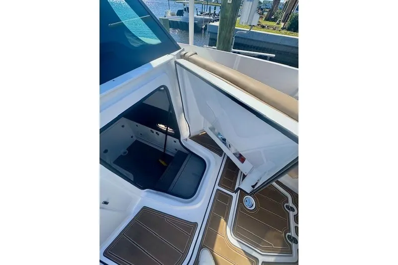 Slide: The Image of 2025 Monterey Elite 27 OB boat interior with open storage compartment and brown flooring. - 56