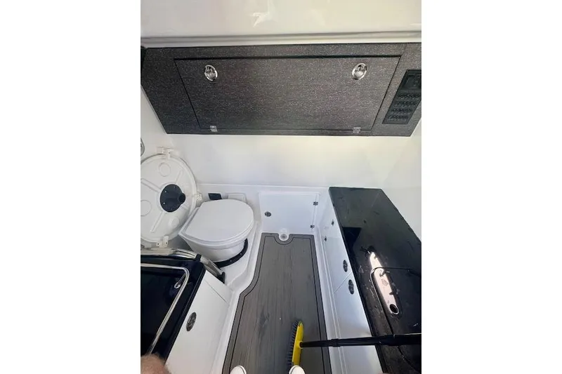 Slide: The Image of Interior of 2025 Monterey Elite 27 OB boat, featuring a compact bathroom setup. - 57
