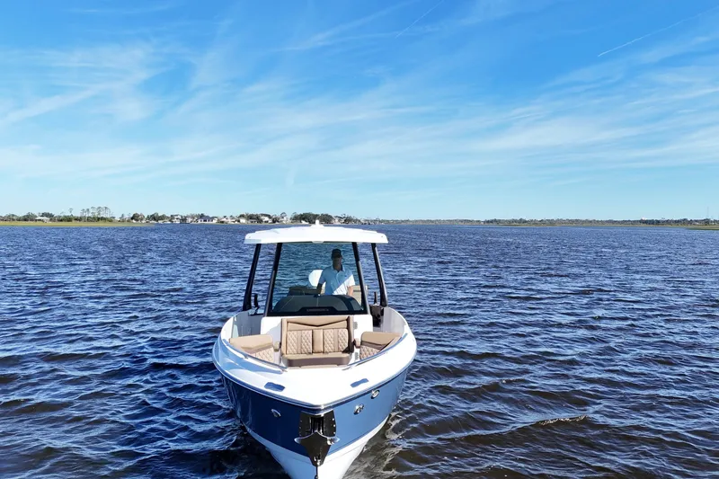 Slide: The Image of 2025 Monterey Elite 27 OB boat cruising on a serene lake under a clear blue sky. - 7