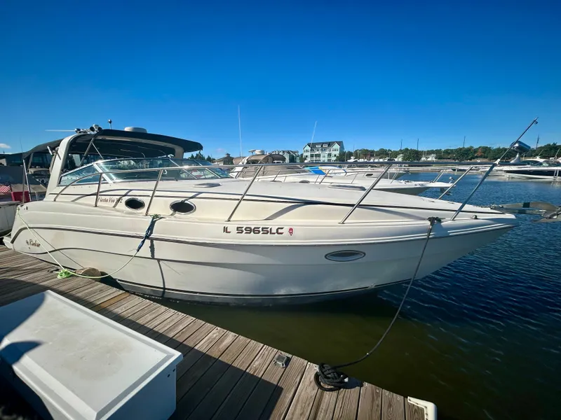 The Image of 2002 Rinker 342 Fiesta Vee boat docked at a marina under clear blue skies. - 0