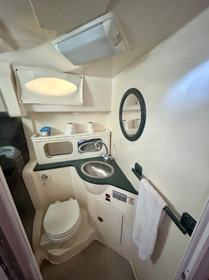 Slide: The Image of 2002 Rinker 342 Fiesta Vee boat bathroom with sink, toilet, and mirror. - 10