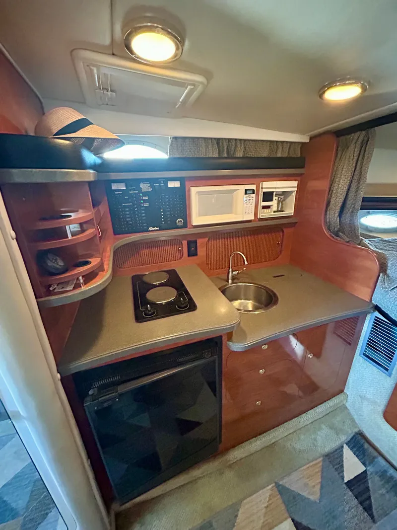 Slide: The Image of 2002 Rinker 342 Fiesta Vee boat kitchen with stove, sink, and microwave. - 11