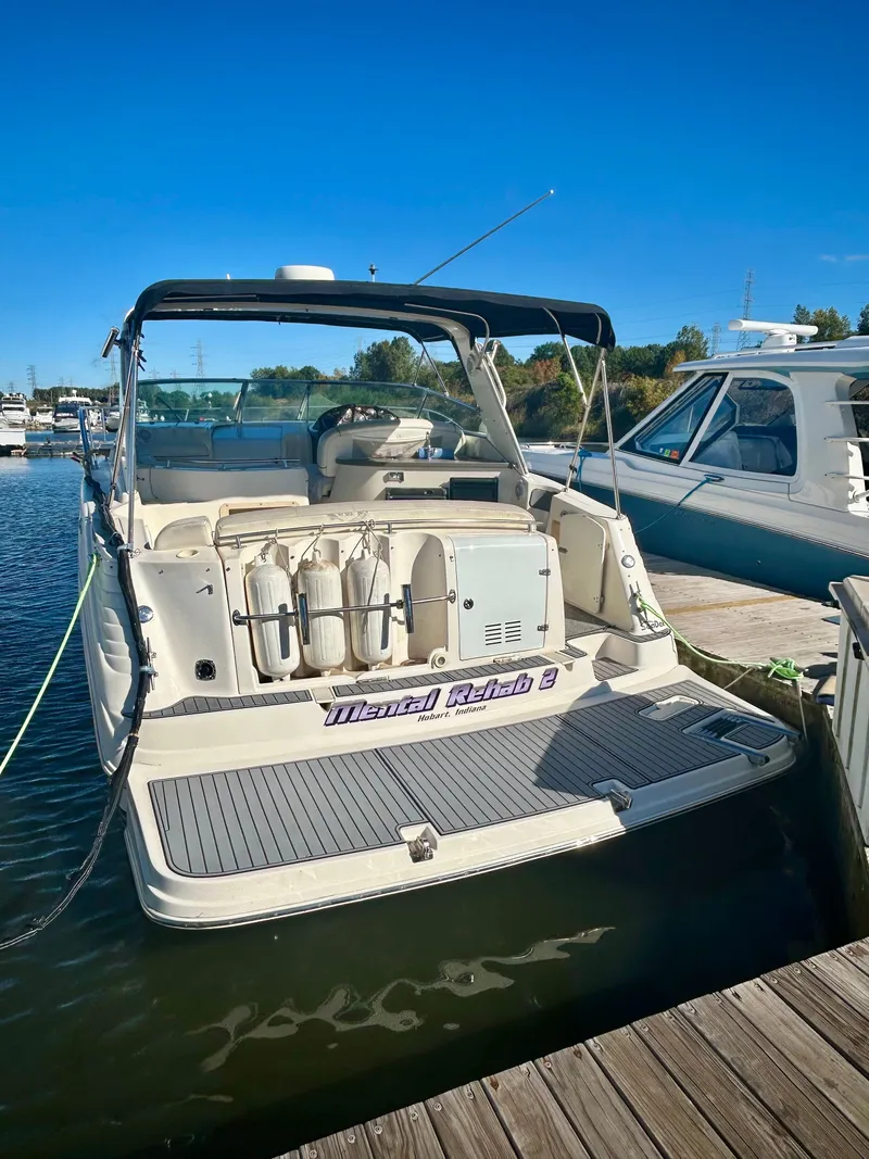 Slide: The Image of 2002 Rinker 342 Fiesta Vee boat docked at marina under clear blue sky. - 2