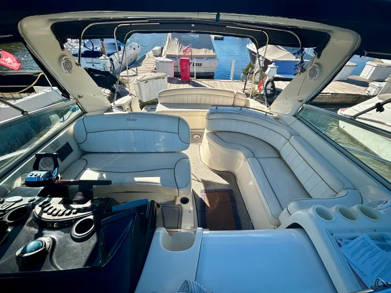 Slide: The Image of Interior of a 2002 Rinker 342 Fiesta Vee boat with white seating and dock view. - 20