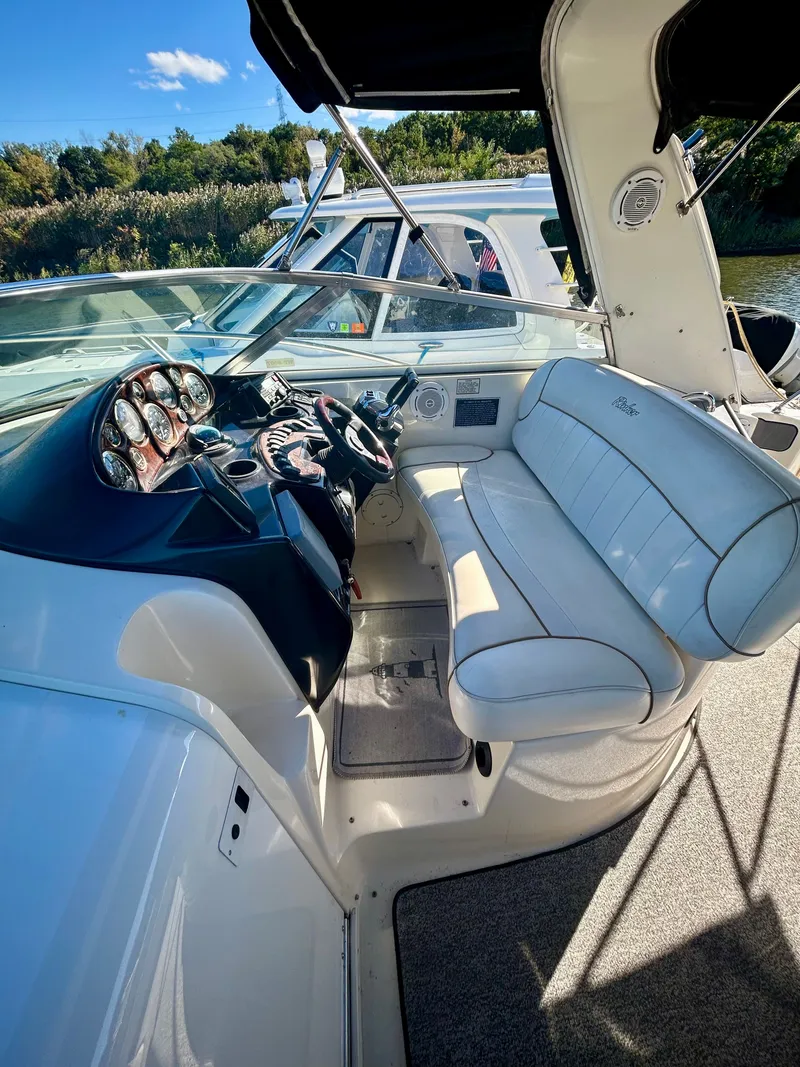 Slide: The Image of 2002 Rinker 342 Fiesta Vee boat interior with white seating and control panel. - 8