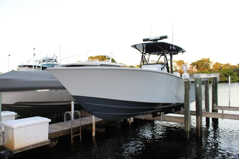 Slide: The Image of 2019 Conch 33 boat docked on a lift, side view. - 1