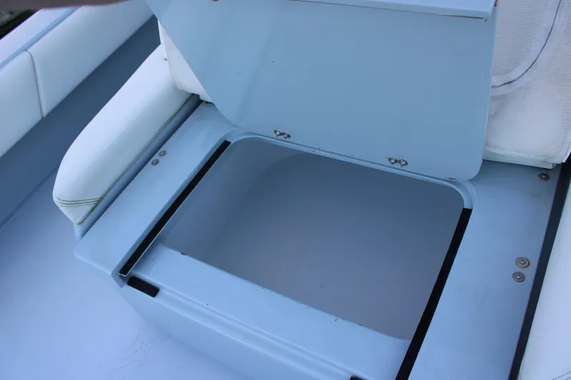 Slide: The Image of Open storage compartment on a 2019 Conch 33 boat, featuring blue and white seating. - 15