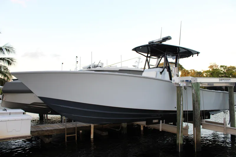 Slide: The Image of 2019 Conch 33 boat docked on a lift, featuring sleek design and modern equipment. - 2