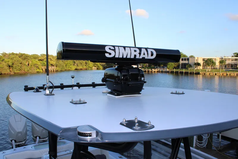 Slide: The Image of 2019 Conch 33 boat with Simrad radar on calm water, surrounded by lush greenery. - 26