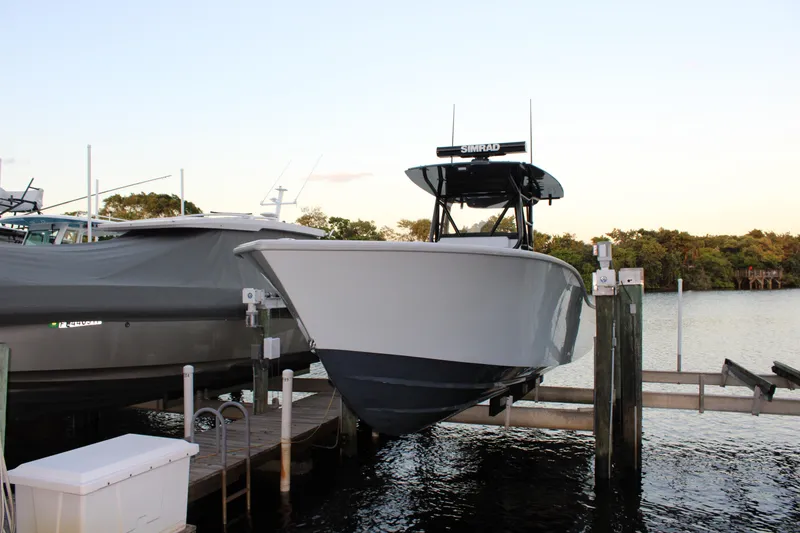 Slide: The Image of 2019 Conch 33 boat docked on a lift by the water. - 32