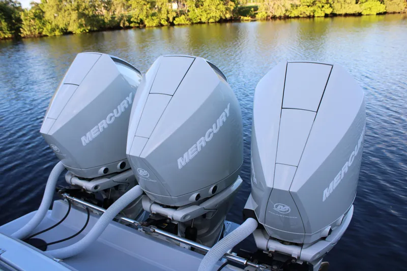 Slide: The Image of Triple Mercury outboard engines on a 2019 Conch 33 boat, set against a serene water backdrop. - 4