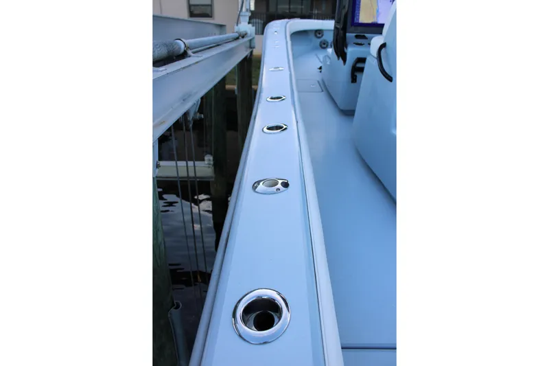 Slide: The Image of 2019 Conch 33 boat deck with rod holders, docked by the water. - 9