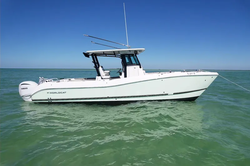 The Image of 2023 World Cat 325 CC boat on calm ocean waters under clear blue sky. - 0