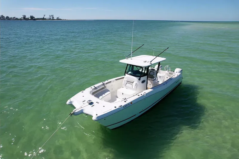 Slide: The Image of 2023 World Cat 325 CC boat anchored in clear turquoise water. - 12