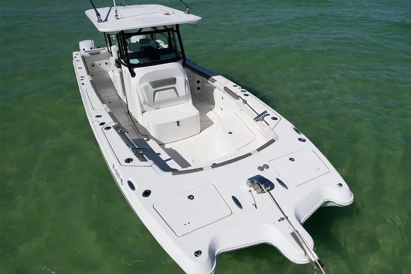 Slide: The Image of 2023 World Cat 325 CC boat on clear green water, showcasing sleek design and spacious deck. - 13