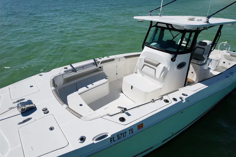 Slide: The Image of 2023 World Cat 325 CC boat on clear water, showcasing spacious deck and seating. - 15