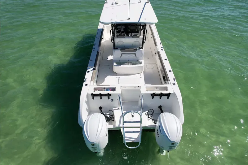 Slide: The Image of 2023 World Cat 325 CC boat on clear green water, rear view with dual engines. - 16