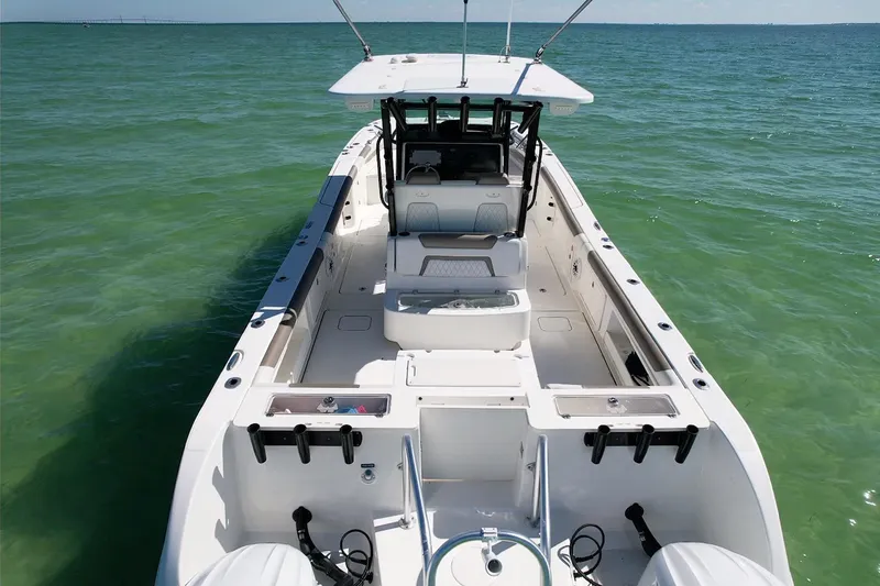 Slide: The Image of 2023 World Cat 325 CC boat on calm ocean waters, showcasing spacious deck layout. - 18