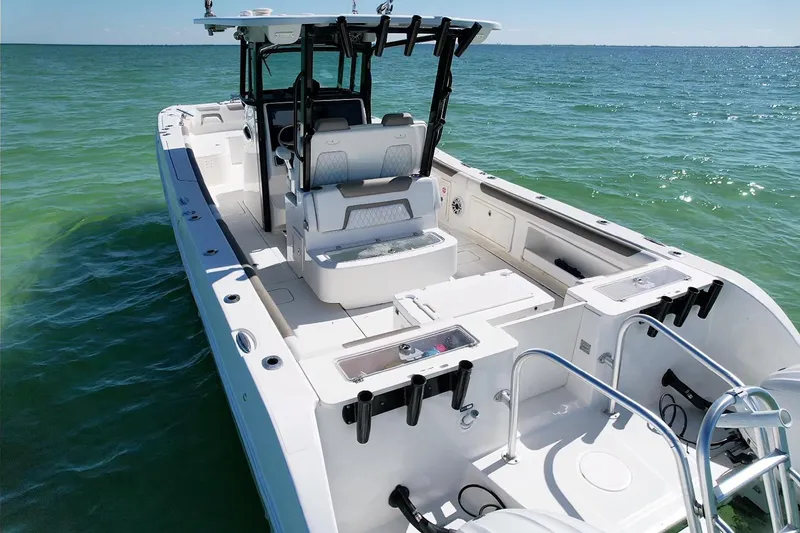 Slide: The Image of 2023 World Cat 325 CC boat on clear ocean water, showcasing spacious deck and seating. - 19