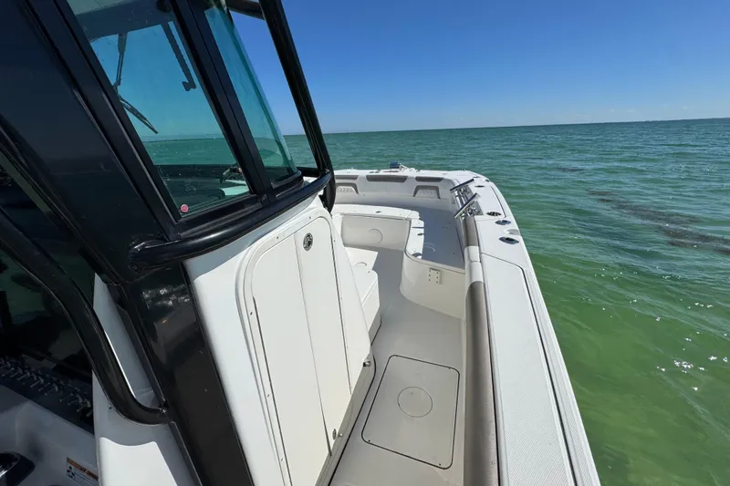 Slide: The Image of 2023 World Cat 325 CC boat on calm ocean waters under clear blue sky. - 23