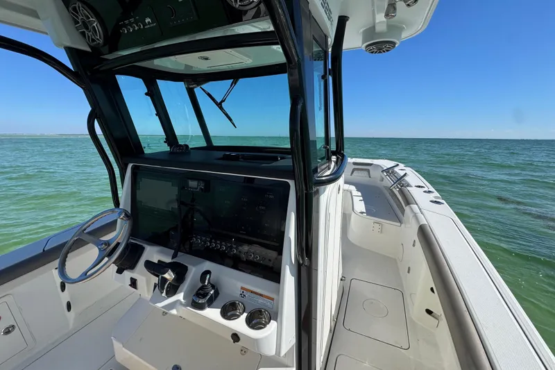 Slide: The Image of 2023 World Cat 325 CC boat interior with ocean view, featuring modern controls and spacious deck. - 24
