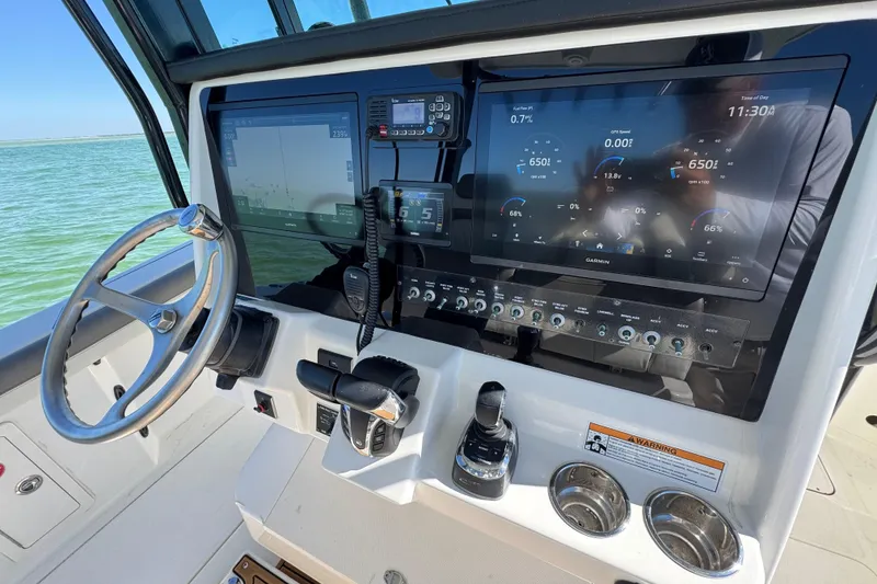 Slide: The Image of 2023 World Cat 325 CC boat dashboard with Garmin displays and steering wheel. - 25