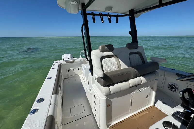 Slide: The Image of 2023 World Cat 325 CC boat interior with seating, on calm ocean waters. - 27