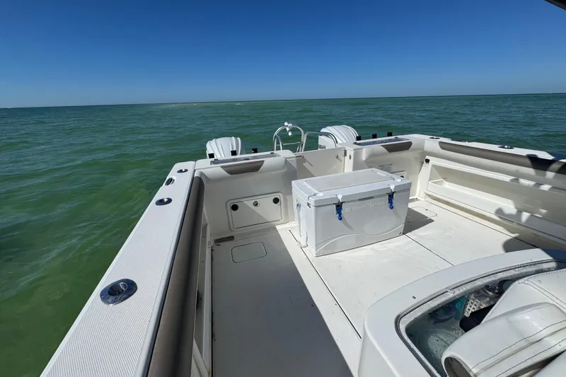 Slide: The Image of 2023 World Cat 325 CC boat on open water, featuring spacious deck and storage. - 28