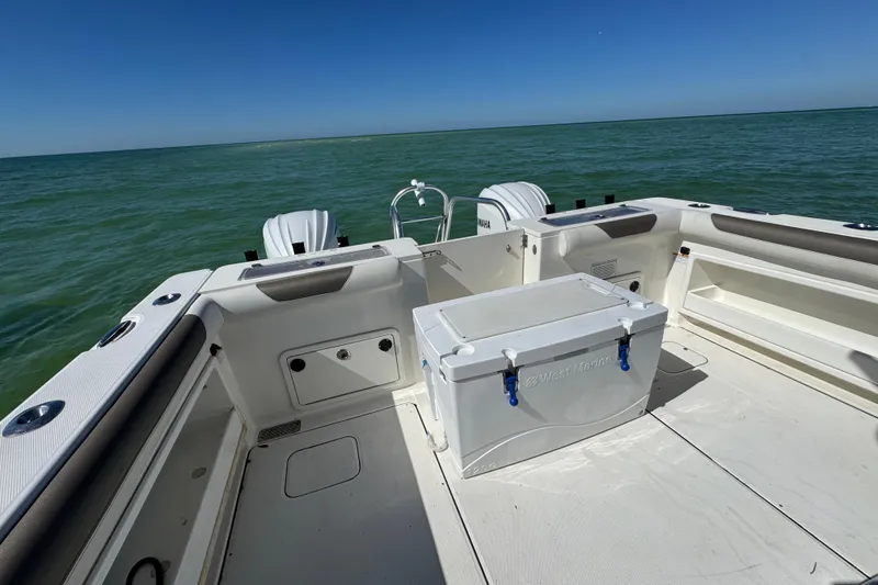 Slide: The Image of 2023 World Cat 325 CC boat deck with cooler, ocean view, and twin engines. - 29