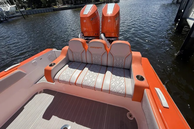 Slide: The Image of 2025 Concept 32' CC boat with orange and white seating, dual engines, docked on water. - 2