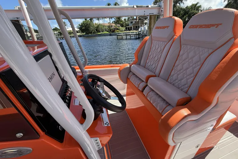 Slide: The Image of 2025 Concept 32' CC boat interior with orange and white seating, steering wheel, and Garmin display. - 6