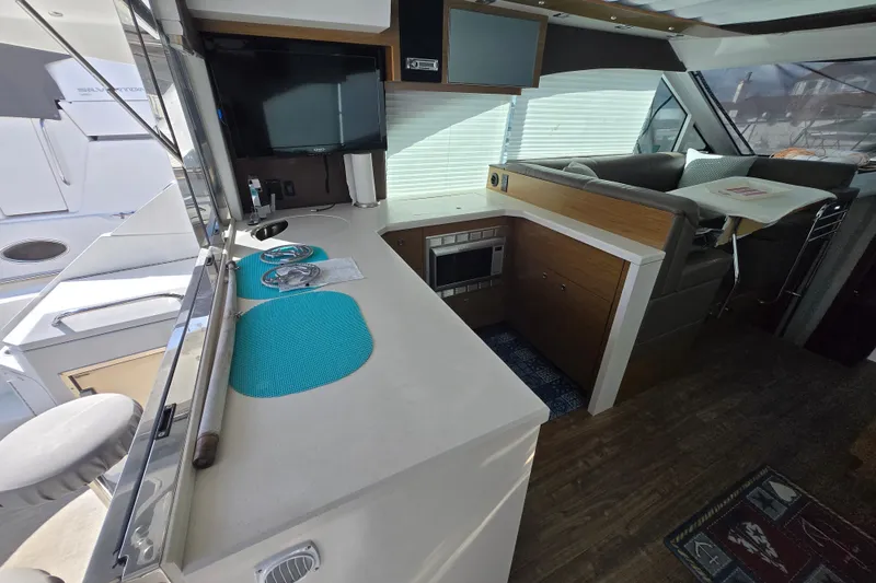 Slide: The Image of 2016 Cruisers Sport Series 45 Cantius yacht interior with two bar stools. - 26