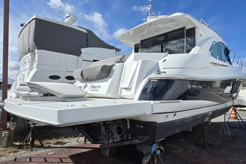 Slide: The Image of 2016 Cruisers Sport Series 45 Cantius yacht for sale, displayed on stands under a blue sky. - 4