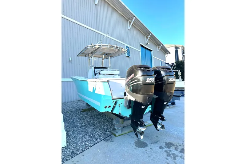 Slide: The Image of 2006 Southport 26 Center Console boat with twin Mercury 250 engines, docked outdoors. - 2