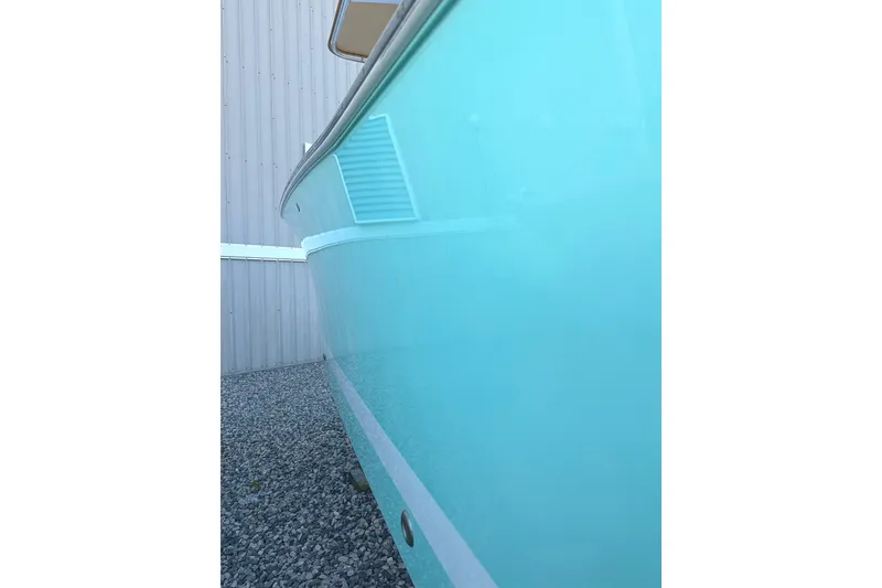 Slide: The Image of 2006 Southport 26 Center Console boat with turquoise hull, parked on gravel. - 3